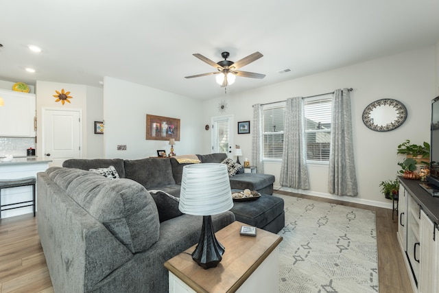 living room featuring ceiling fan and light hardwood / wood-style flooring