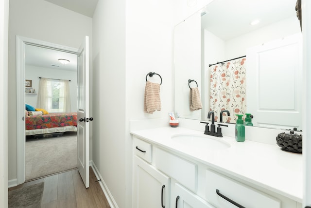 bathroom with a shower with shower curtain, hardwood / wood-style floors, and vanity