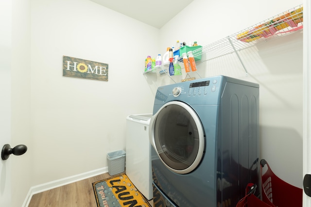 laundry area featuring washing machine and dryer and hardwood / wood-style flooring