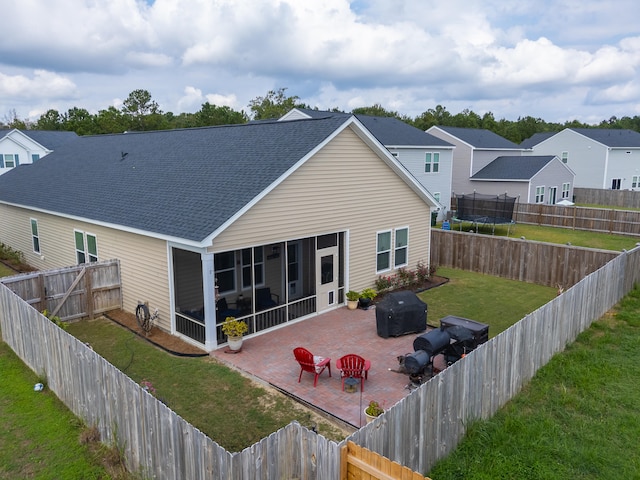 back of house with a sunroom, a yard, and a patio