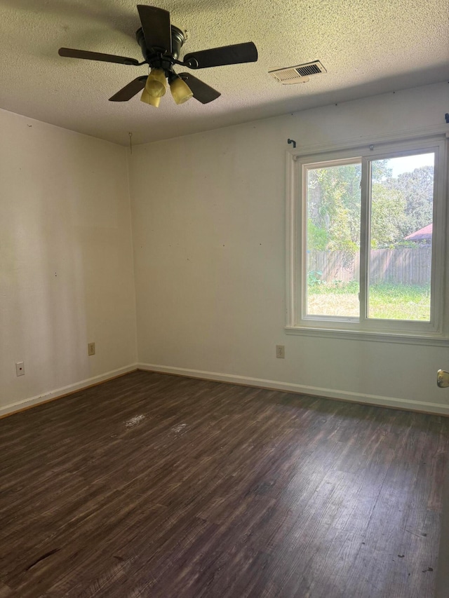 empty room featuring ceiling fan, dark hardwood / wood-style flooring, and a textured ceiling