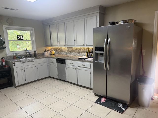 kitchen featuring visible vents, light tile patterned floors, a sink, stainless steel appliances, and decorative backsplash