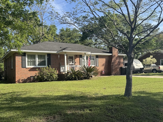 view of front of home with brick siding, a front lawn, and a porch