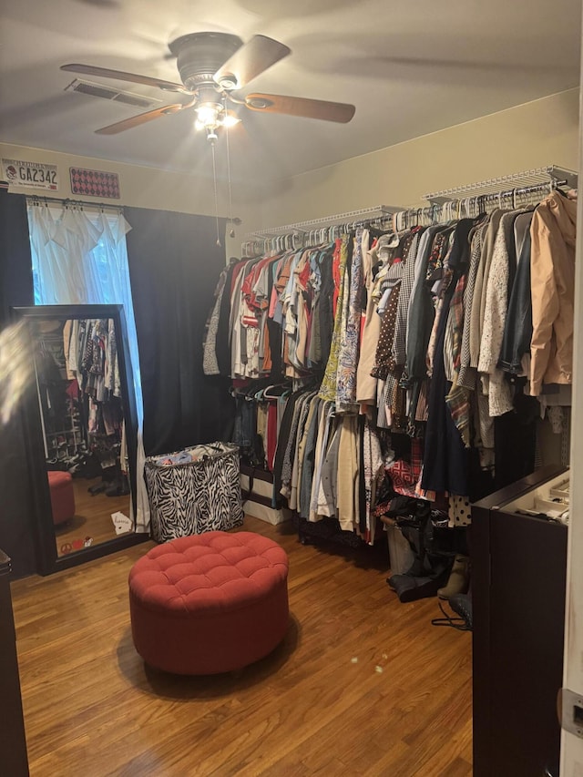 spacious closet with a ceiling fan and wood finished floors