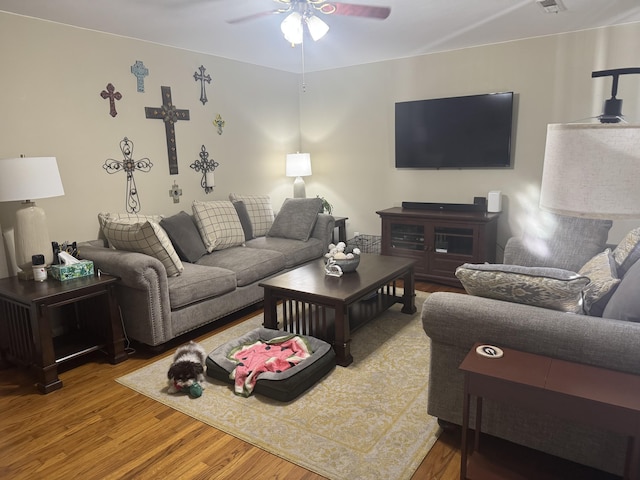 living room featuring visible vents, a ceiling fan, and wood finished floors