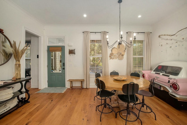 dining room with a notable chandelier, ornamental molding, and light hardwood / wood-style floors