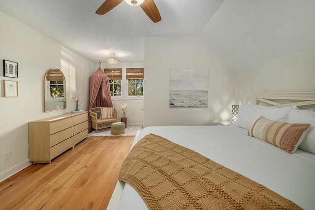 bedroom featuring ceiling fan, lofted ceiling, and light wood-type flooring