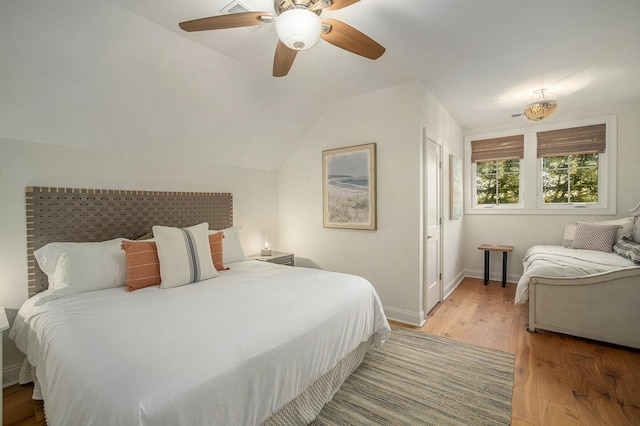 bedroom with ceiling fan, lofted ceiling, and light hardwood / wood-style flooring