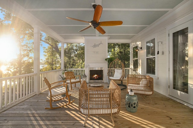 wooden deck featuring a fireplace and ceiling fan