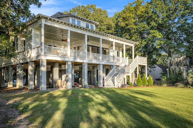 rear view of property featuring ceiling fan and a lawn