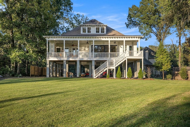 rear view of property featuring a lawn and ceiling fan