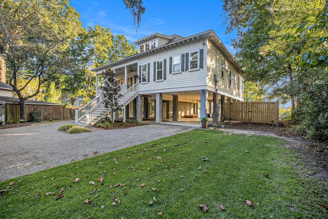 view of front of home featuring ceiling fan, a carport, and a front yard