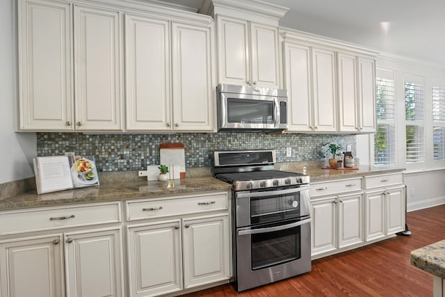 kitchen featuring tasteful backsplash, white cabinets, appliances with stainless steel finishes, and dark hardwood / wood-style flooring