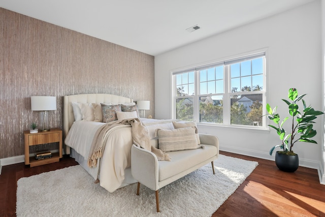 bedroom with dark hardwood / wood-style flooring