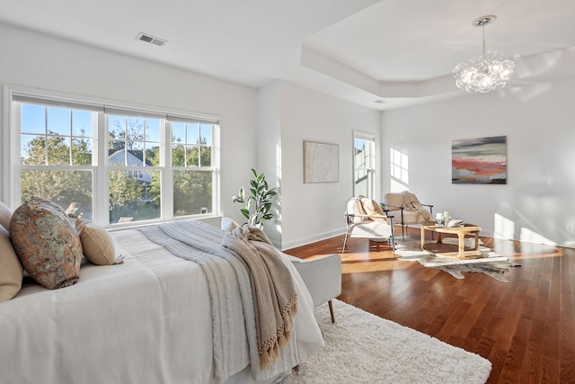 bedroom with wood-type flooring and a notable chandelier