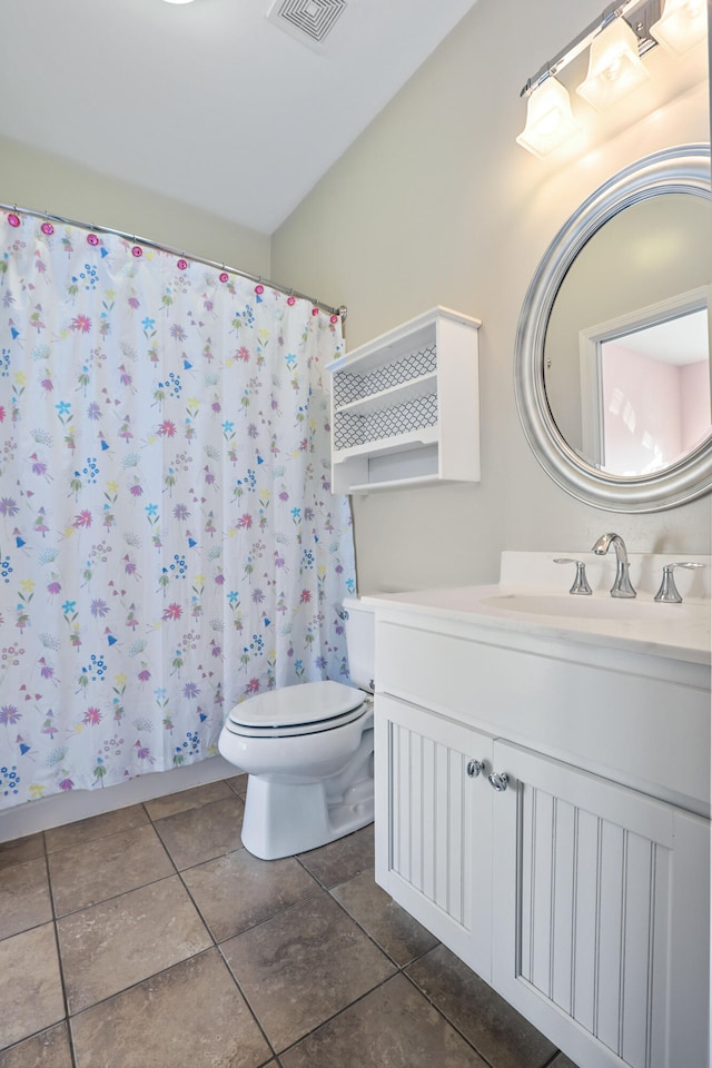 bathroom featuring tile patterned floors, vanity, toilet, and curtained shower