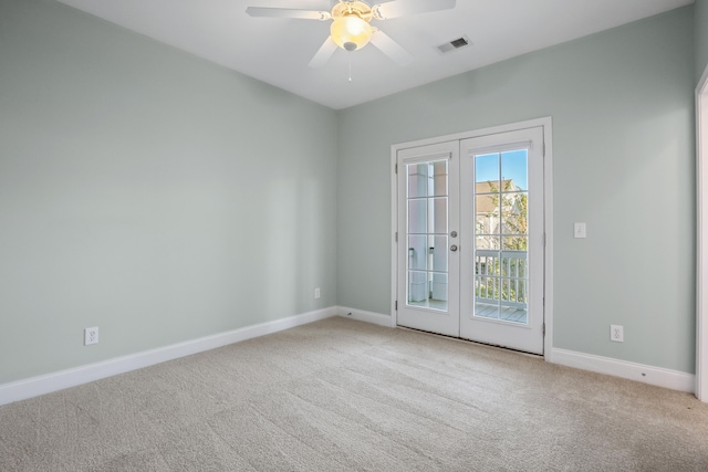 carpeted spare room featuring french doors and ceiling fan