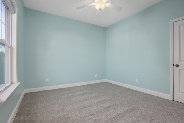 carpeted spare room with ceiling fan