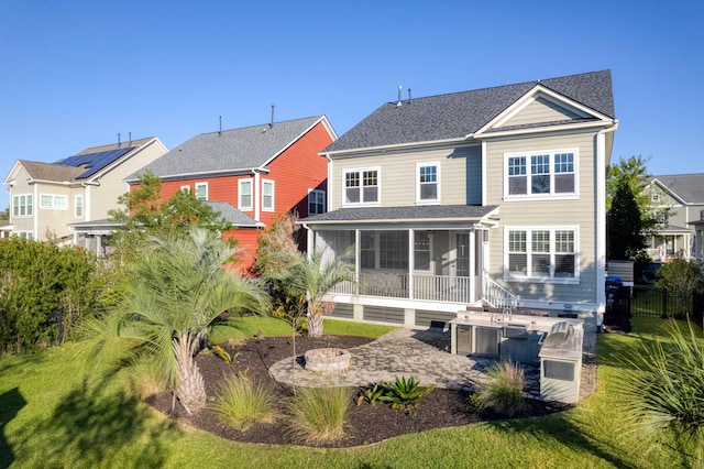 back of house featuring a yard and a sunroom