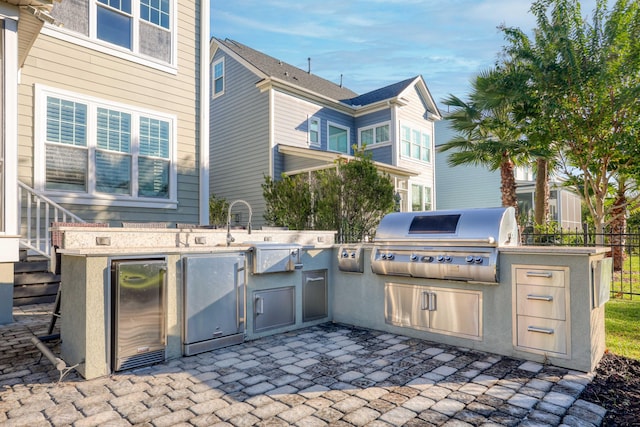 view of patio featuring an outdoor kitchen, sink, and grilling area