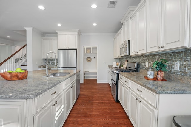 kitchen featuring white cabinets, sink, tasteful backsplash, appliances with stainless steel finishes, and dark hardwood / wood-style flooring