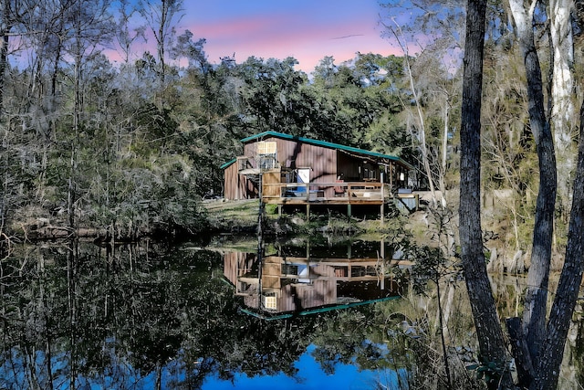 back of property featuring a deck with water view