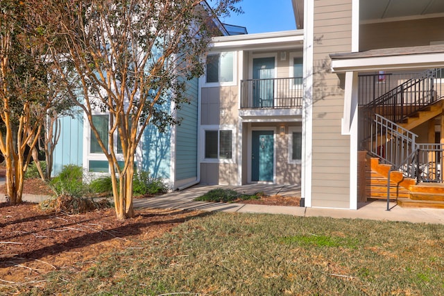 view of front of home with a front yard and a balcony