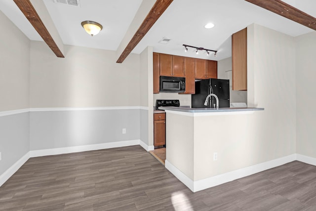 kitchen with beamed ceiling, black appliances, and light hardwood / wood-style floors