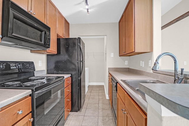 kitchen with light tile patterned floors, black appliances, sink, and track lighting