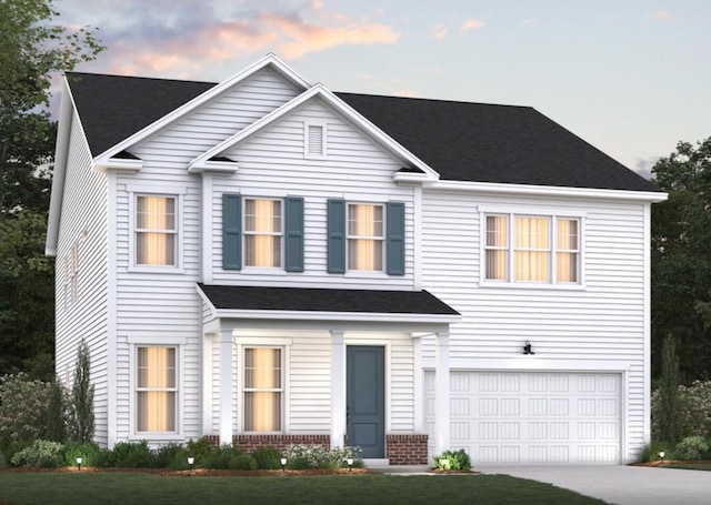 view of front of property with a yard and a garage