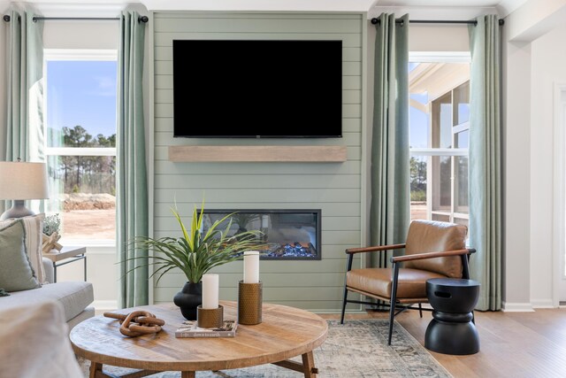 interior space with plenty of natural light, a large fireplace, and light hardwood / wood-style flooring