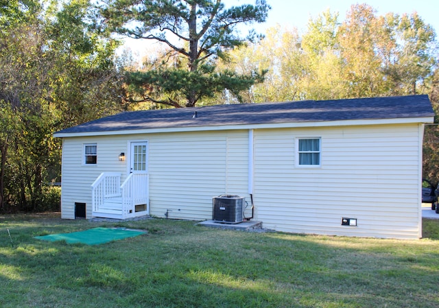 rear view of property featuring a lawn and central AC