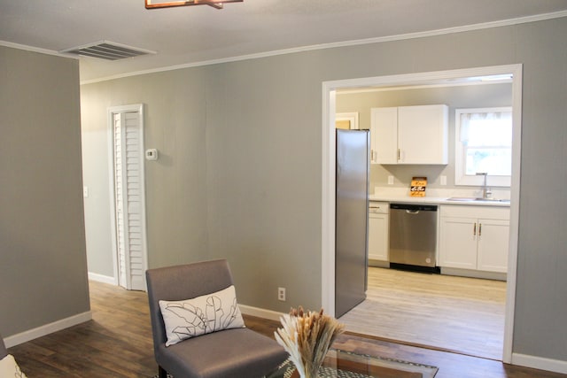 living area with sink, light hardwood / wood-style flooring, and ornamental molding