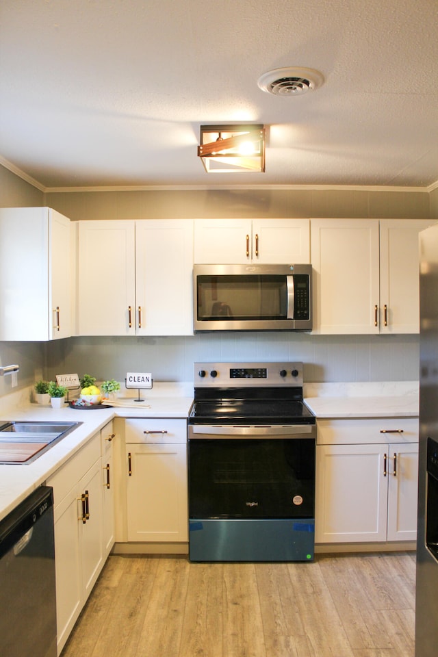 kitchen with white cabinetry, sink, light wood-type flooring, and appliances with stainless steel finishes