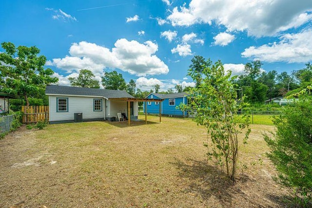 back of property with a yard and fence