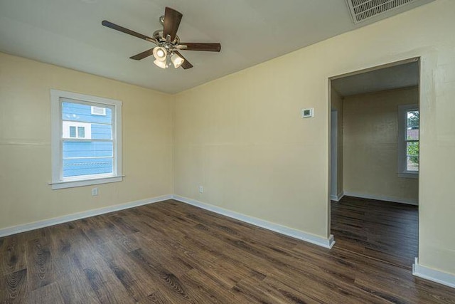 empty room featuring ceiling fan, wood finished floors, visible vents, and baseboards