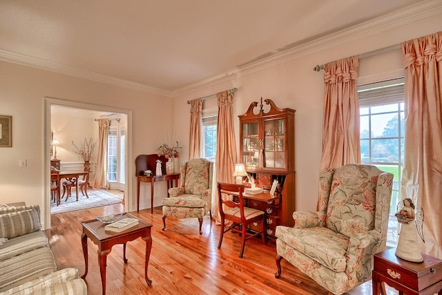 living area featuring ornamental molding, a healthy amount of sunlight, and wood-type flooring