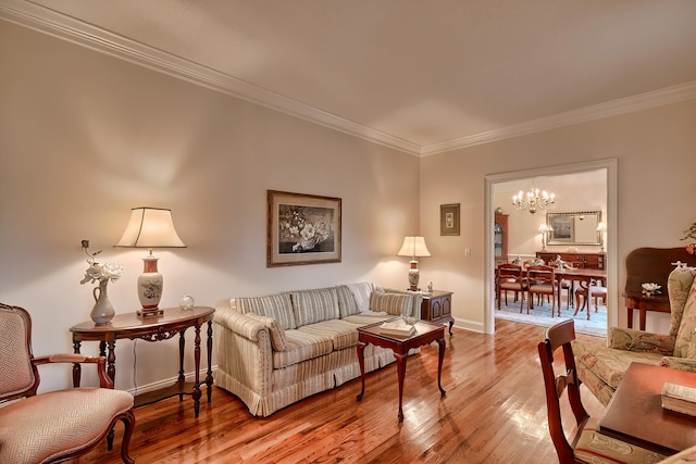 living room featuring hardwood / wood-style flooring, crown molding, and a notable chandelier