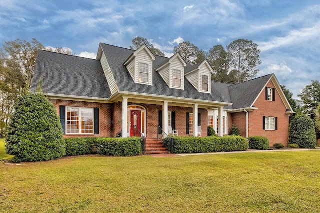 cape cod home with a porch and a front lawn