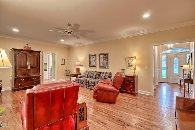 living room with crown molding, light hardwood / wood-style flooring, and ceiling fan