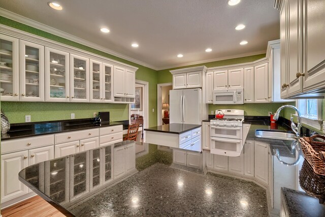 kitchen featuring white appliances, white cabinetry, crown molding, and sink