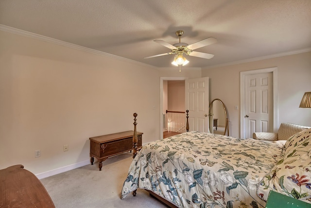 carpeted bedroom with a textured ceiling, ceiling fan, and crown molding