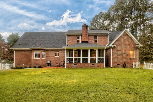 rear view of property with a sunroom and a yard