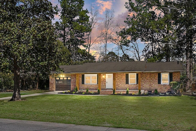 ranch-style house with a front lawn, brick siding, a garage, and driveway