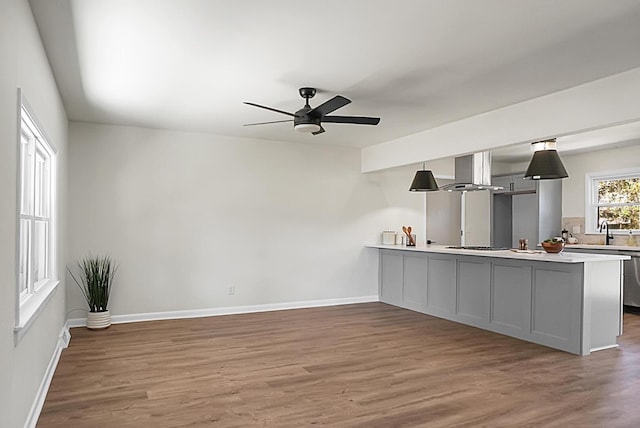 bar with baseboards, a ceiling fan, wood finished floors, and island range hood