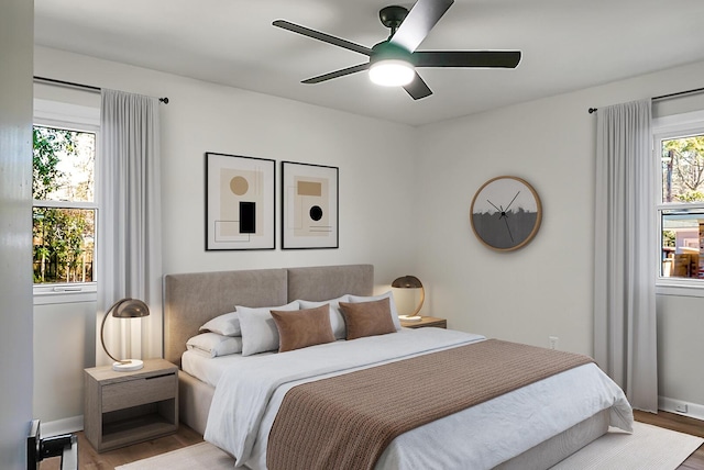 bedroom with ceiling fan, baseboards, and wood finished floors