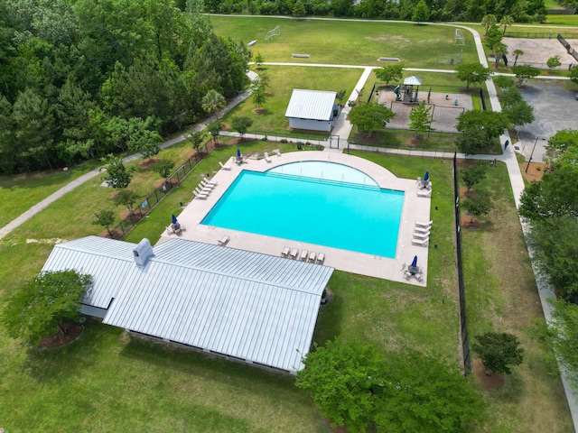 community pool featuring fence and a yard