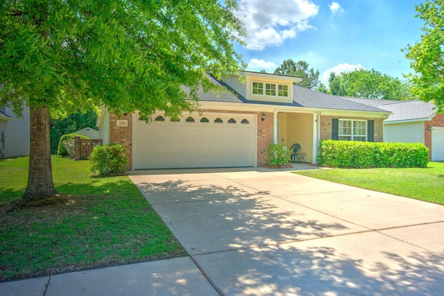 traditional-style home with a garage, a front yard, brick siding, a shingled roof, and concrete driveway