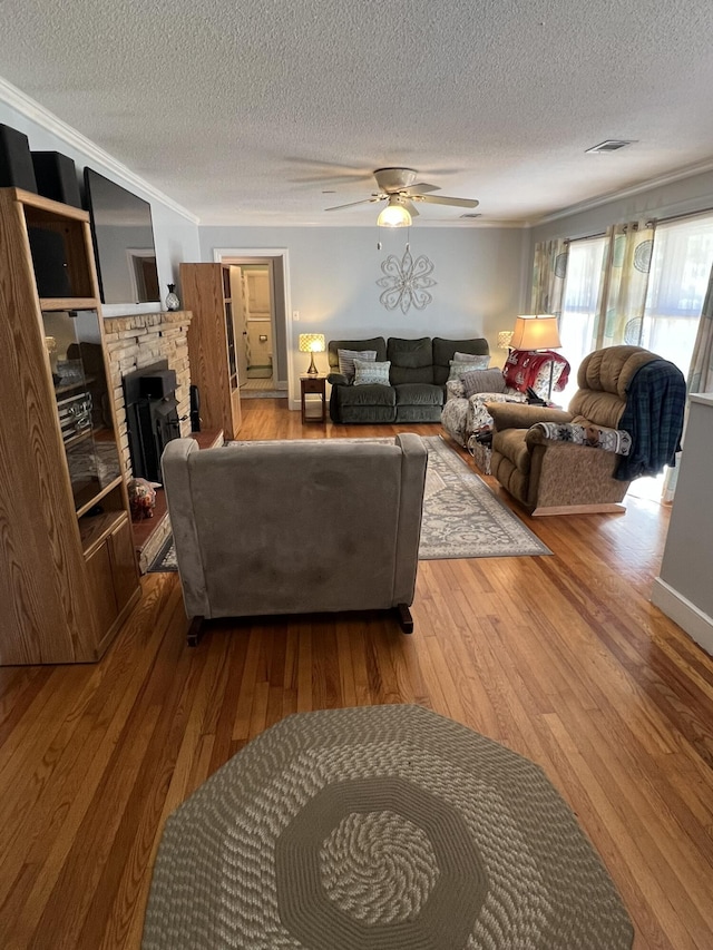 111 Newington Rd, Summerville, SC 29485 - living room featuring visible vents, crown molding, a stone fireplace, and hardwood / wood-style flooring
