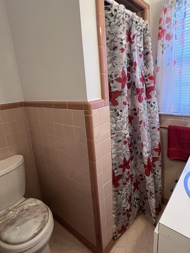 111 Newington Rd, Summerville, SC 29485 - bathroom featuring toilet, wainscoting, tile patterned flooring, and tile walls